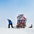 Mann tranzportiert viele Rodeln.