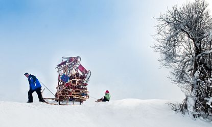 Mann tranzportiert viele Rodeln.