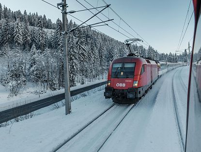 Zug fährt im Winter bei Schnee.