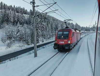 Zug fährt im Winter bei Schnee.