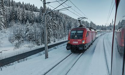 Zug fährt im Winter bei Schnee.