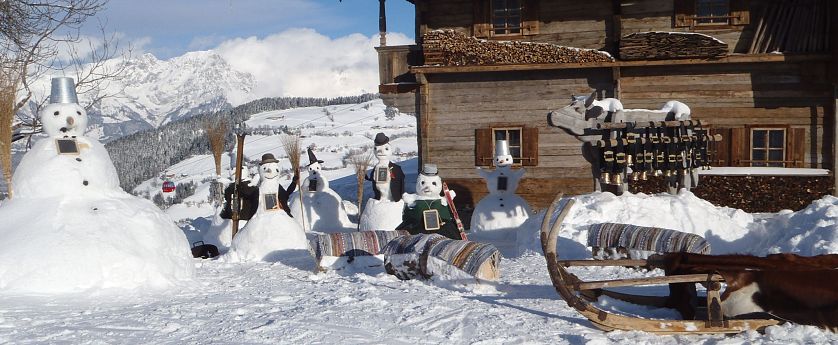 Schneemänner vor der Simonalm im Winter.