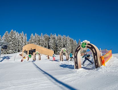 Kleine Skifahrer die im Hans im Glück Skiparkour das Skifahren spielerisch lernen.