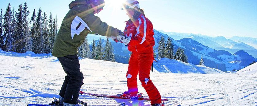 Frau lehrnt das Skifahren von ihrem Skilehrer.