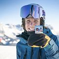 Eine Frau in Skikleidung zeigt ihren Skipass.
