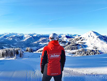 SkiWelt Mitarbeiter vor traumhafter Bergkulisse.