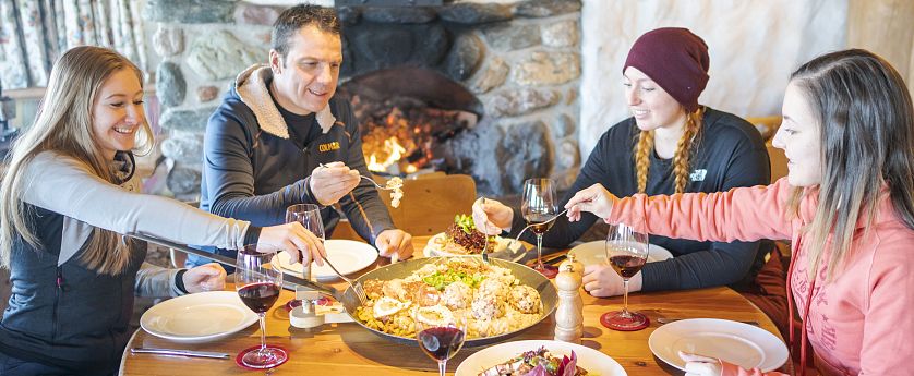 Freunde sitzen zusammen am Tisch und essen.