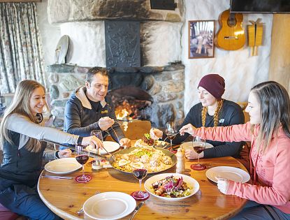 Freunde sitzen zusammen am Tisch und essen.