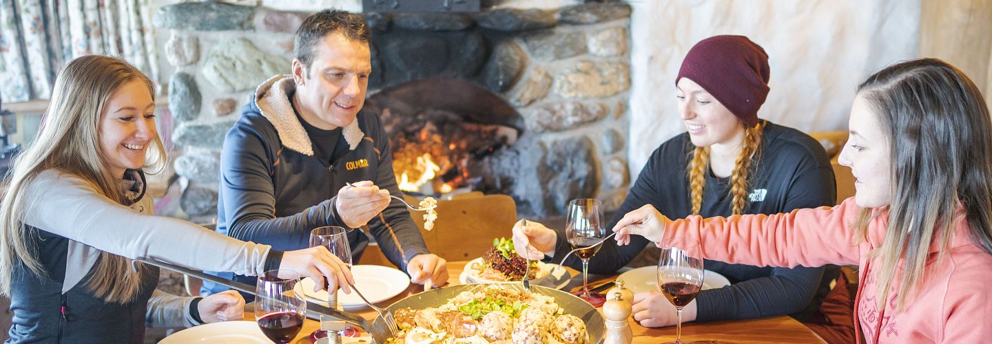 Freunde sitzen zusammen am Tisch und essen.