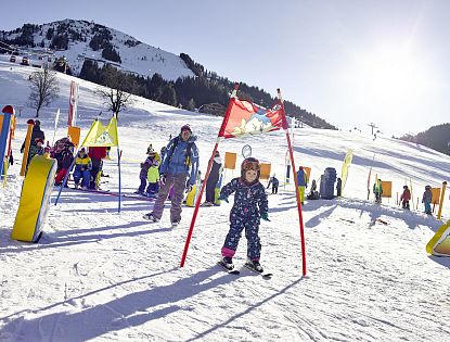 Kind fährt durch Hinderniss bei einem Skirennen.