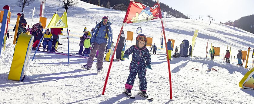 Kind fährt durch Hinderniss bei einem Skirennen.