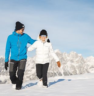 Zwei Winterwanderer die von der Brandstadl Bergstation zum Brandstadlkreuz in Scheffau wandern.