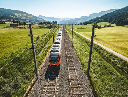 Zug fährt auf Schienen im Sommer.