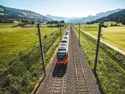 Zug fährt auf Schienen im Sommer.