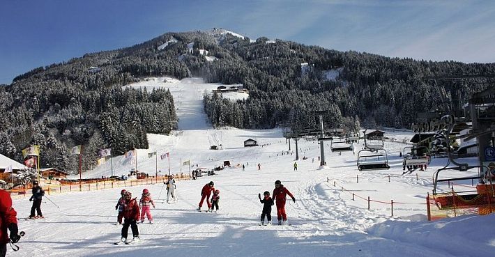 SkiWelt oefenweide met kinderen in Westendorf met uitzicht op de berg