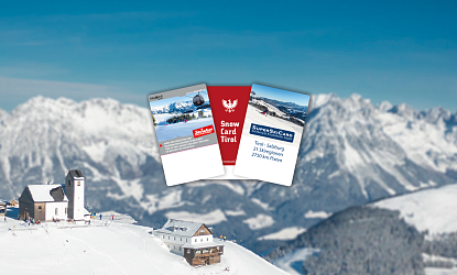 Drie skikaarten zweven voor een besneeuwd berglandschap met een skihut en bergen op de achtergrond.