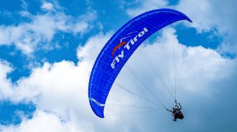 Flugschule Fly Tirol Tandenflug Paragleiten in der Luft Wolken blauer Himmel
